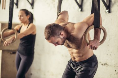 Spor salonunda egzersiz daldırma kullanarak yapan fitness yakışıklı erkek yüzük