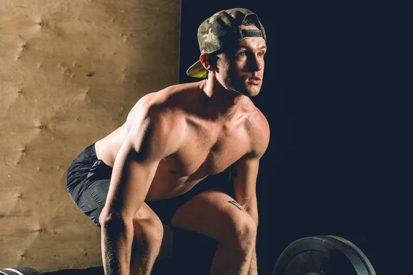 Man lyfta vikter. muskulös man träning i gym gör övningar med skivstång — Stockfoto
