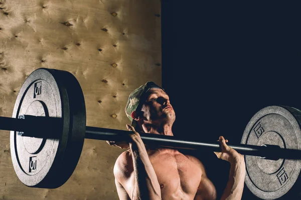 Adam ağırlık kaldırıyordu. kaslı adam egzersiz halter ile egzersizleri yapıyor spor salonunda — Stok fotoğraf