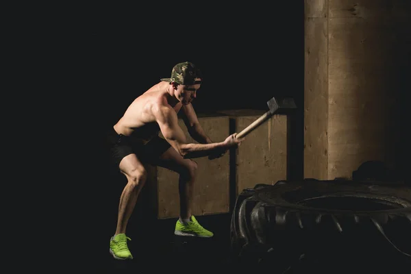 Man träffar däck - träning på Gym med hammare och traktor däck Siluet — Stockfoto