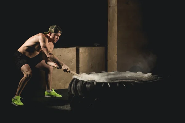 Hombre golpea neumático - Entrenamiento en el gimnasio con el martillo y el tractor neumático Siluet — Foto de Stock