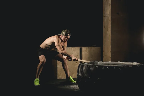 Man träffar däck - träning på Gym med hammare och traktor däck Siluet — Stockfoto