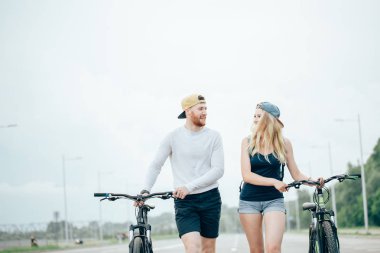 mutlu genç çift elele ve Bisiklete binme