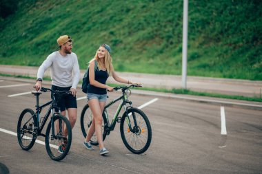 Bisiklet birlikte mercek parlaması ile çarpıcı günbatımı için yolda yürürken Çift