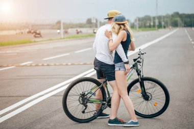 mutlu bir adam kız bisikleti onun çubuk üzerinde sahilde götürecek