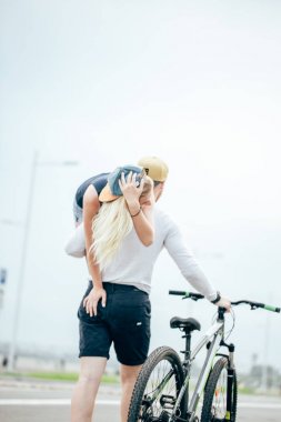 Çift bir yaz gününde gülümseyen, onun kız arkadaşı omzuna tutmak adam