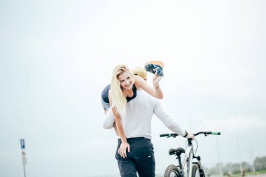 Çift bir yaz gününde gülümseyen, onun kız arkadaşı omzuna tutmak adam