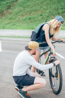 Genç adam bir tekerlekli bisiklet tamir