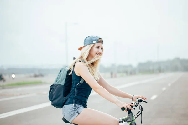 Bela jovem está sentada em uma bicicleta - Ao ar livre — Fotografia de Stock