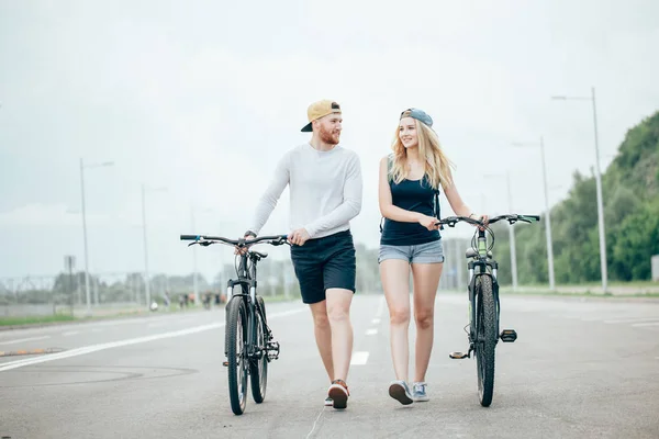 도 자전거를 함께 걷는 젊은 부부 — 스톡 사진