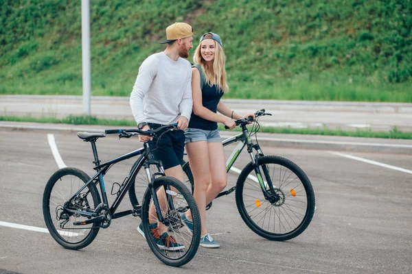 Joyeux jeune couple tenant la main et chevauchant à vélo — Photo