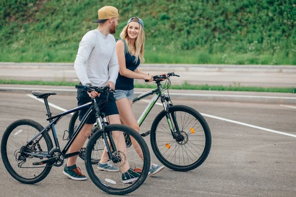 Junges Paar zu Fuß mit Fahrrädern unterwegs — Stockfoto