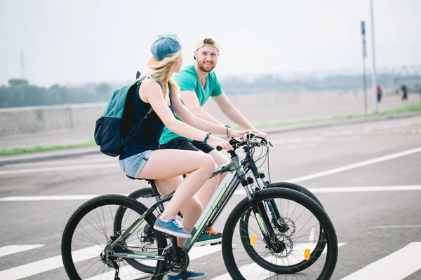 Pareja activa en un paseo en bicicleta por el campo en un día soleado — Foto de Stock