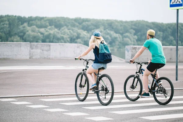 Joven pareja deportiva montando en bicicleta. Vista trasera . — Foto de Stock