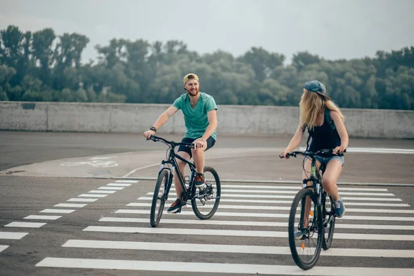 Feliz casal motociclista com bicicleta de montanha no campo — Fotografia de Stock