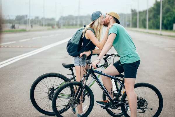 Beau jeune couple amoureux marchant à vélo, embrassant et embrassant — Photo