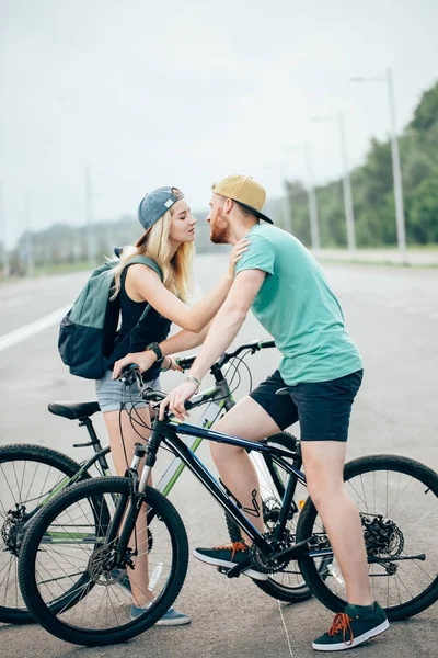 Couple sportif romantique embrasser sur fond flou avec des vélos — Photo