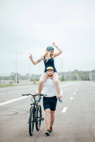 공원에서 자전거 타기, 웃 고, 어깨에 여자 친구 커플 — 스톡 사진