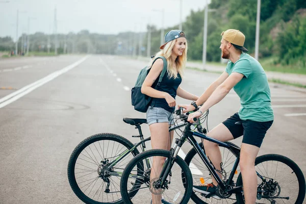 Jovem casal hipster de mãos dadas em pé na estrada — Fotografia de Stock