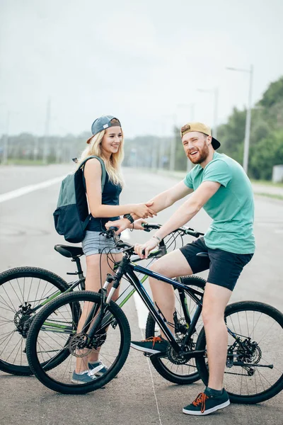 Para młoda hipster, trzymając się za ręce stoi na drodze — Zdjęcie stockowe