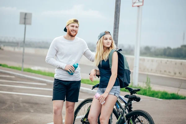 Para młoda hipster, trzymając się za ręce stoi na drodze — Zdjęcie stockowe