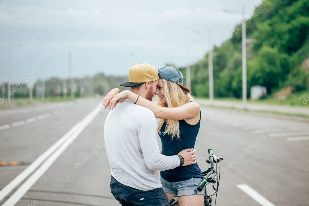 Happy man giving girlfriend a lift on his crossbar of bike on the beach