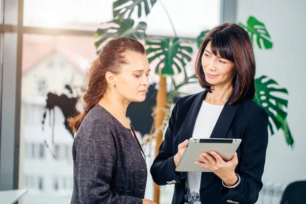 Empresaria con colega femenina usando tableta — Foto de Stock