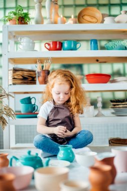 Kızıl saçlı kız lotus poz Studio oturan seramik bardak yapılır