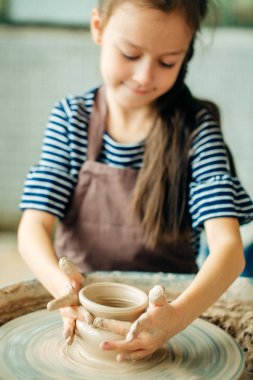Çocuk kil pot sculpts. çömlekçi çarkında modelleme.