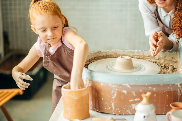 Mère et fille moule avec de l'argile sur la poterie — Photo