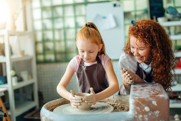 Mère et fille moule avec de l'argile sur la poterie — Photo