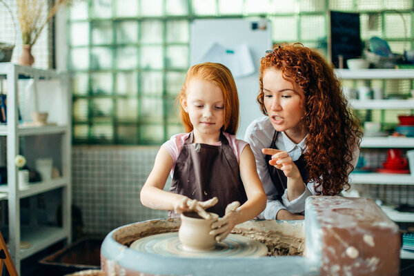 teacher and student make pitcher of pottery wheel