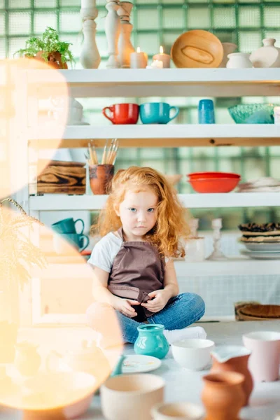 Girl wih many cups made from clay sitting in pottery studio — Stock Photo, Image