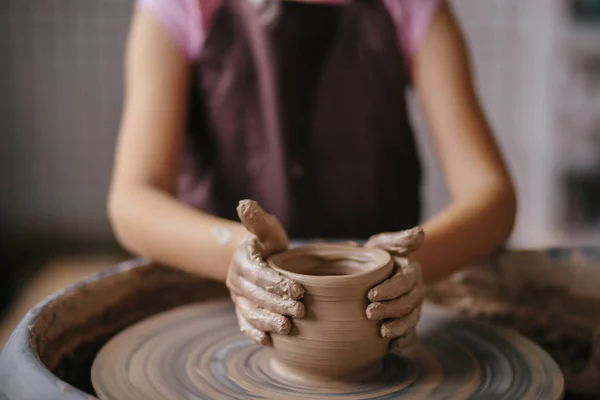 Mains de jeune potier, gros plan mains faites tasse sur roue de poterie — Photo