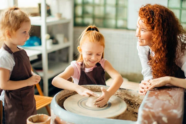 Madre y dos hijas pelirrojos hicieron taza de barro con rueda de cerámica — Foto de Stock