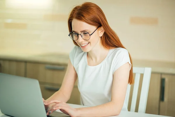 Улыбающаяся женщина с ноутбуком в домашнем офисе — стоковое фото