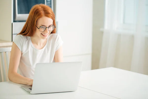 Gülümseyen ve dizüstü bilgisayar ekranına bakarak güzel genç kadın — Stok fotoğraf