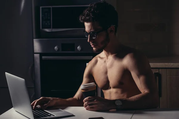 Adatto all'uomo Usando il computer portatile e bere caffè al mattino — Foto Stock