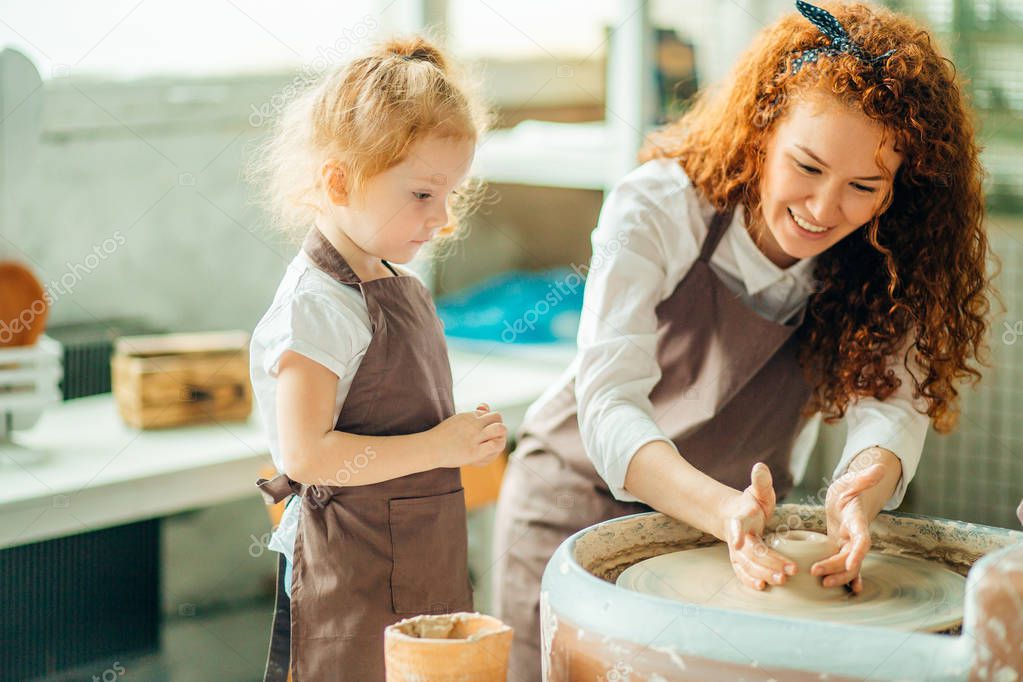 teacher and student make pitcher of pottery wheel