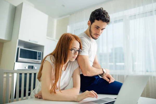 Coppia utilizzando il computer portatile sulla scrivania a casa e pensare — Foto Stock