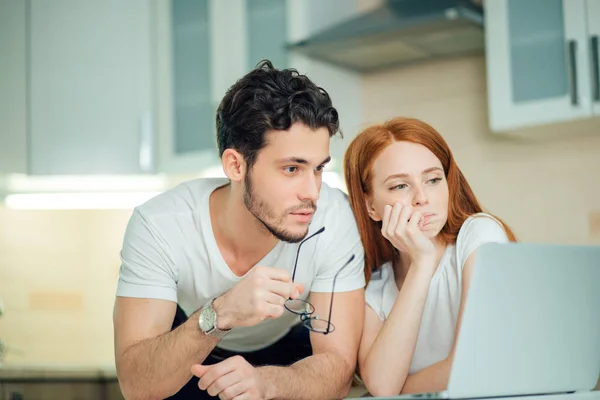 Casal usando laptop na mesa em casa e pensar — Fotografia de Stock