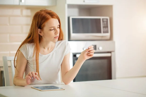 Woman is shopping online with tablet pc and holding card in hand — Stock Photo, Image