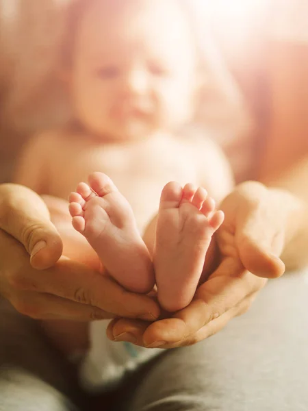 Nyfödd baby ben i mödrar härlig hand med mjukt fokus på spädbarn fot — Stockfoto