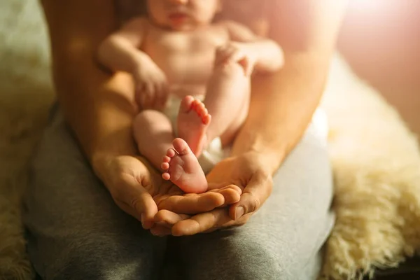 Pieds de bébé entre les mains de la mère. Les pieds des nouveau-nés sur les mains — Photo