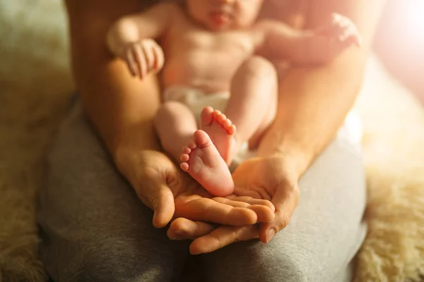 Mère tient les pieds des nouveau-nés. Petits pieds dans la main des femmes . — Photo