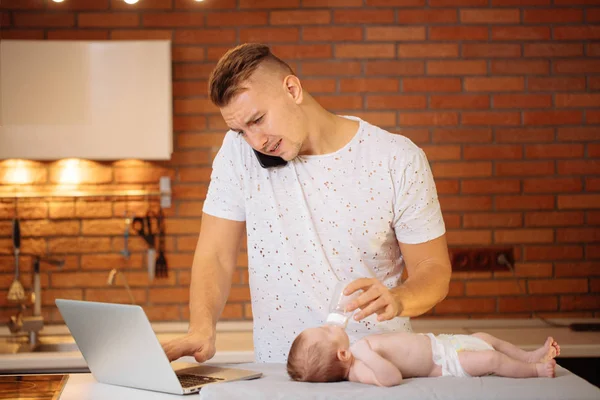 Hombre trabajando desde casa y cuidando del bebé —  Fotos de Stock