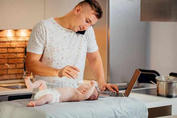 Homem trabalhando em casa e cuidando do bebê — Fotografia de Stock