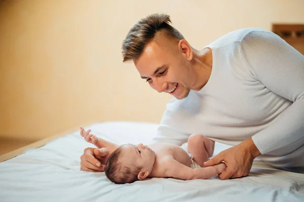 Padre jugando con adorable bebé en el dormitorio —  Fotos de Stock