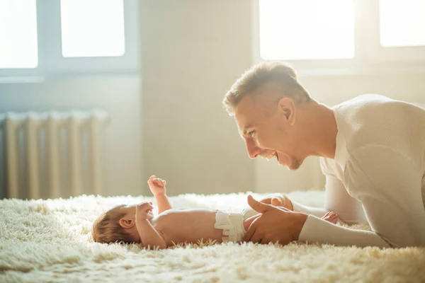 Vader spelen met schattige baby in slaapkamer — Stockfoto