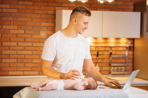 father is changing nappy to his baby boy